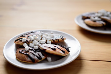 homemade pancakes with marshmallows on plates on table