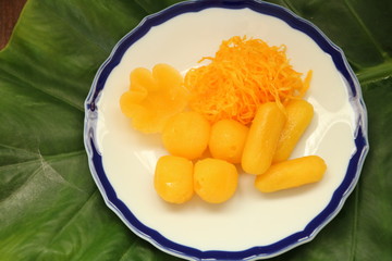 ancient Thai Dessert, thai sweet dessert in plate on green leaf background,egg yoke fudge balls cooked in syrup, Pinched gold egg yolks, appetizer