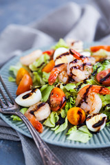 Delicious fresh green salad with shrimps, cherry tomatoes, quail eggs and balsamic sauce