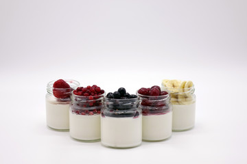 Fresh berries in the jar with the yogurt. On white background.