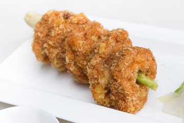 Deep fried shrimp in white plate on the stone table.