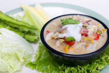 Crab dip with coconut milk and vegetables in bowl.