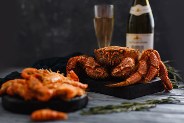 Seafood. Crab hairy close-up, in background bottle of champagne, glass, dark background. Concept expensive food, sea food, Christmas dish.
