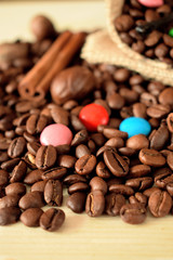 Coffee beans, multicoloured drops, cinnamon and vanilla. Ingredients for making a drink