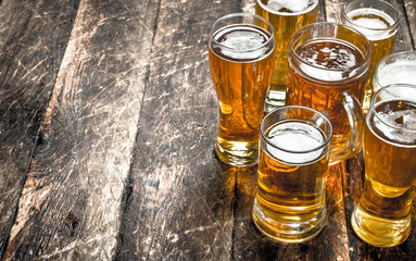 glasses of fresh beer. On wooden background.