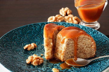 Piece of Banana cake with walnut and caramel fudge. Blue plate background. Close up. Selective...