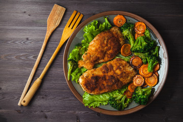 Chicken steak in breadcrumbs with vegetables on a plate. Menu, restaurant concept. Served in. Top view