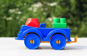 beautiful bright kids toy train made of plastic outdoors in the summer on a white table