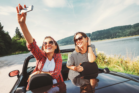 Two female freinds take a selfie photo during their auto travel