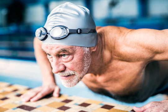 Senior man doing push ups by swimming pool