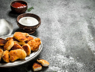 Chicken nuggets with various sauces.