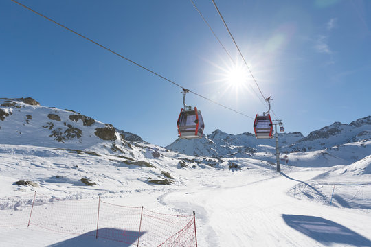 Cableway lift cable cars, gondola cabins on winter snowy mountains background beautiful scenery.