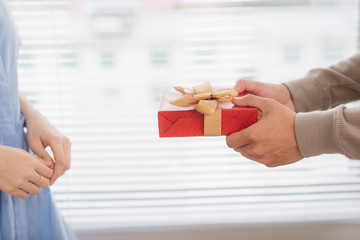 Obraz premium Couple in love. Romantic man giving gift to his girlfriend