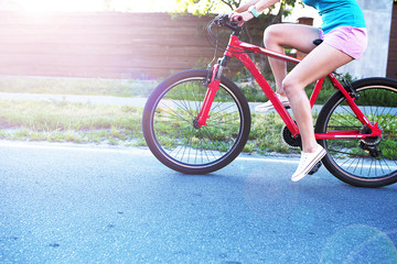 Fototapeta na wymiar Close up photo of a Beautiful female legs riding on bike in the city