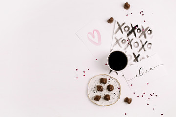 Artistic concept with painted cards, coffee and sweets. Flat lay, top view Valentine's Day or Love composition.