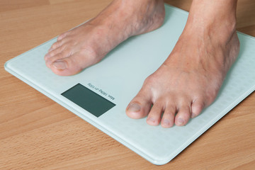 Healthy diet, fitness and weight loss concept. The legs of a young woman on the scales. Checking the weight.