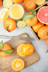 Citrus background. Colorful fresh citrus fruit on table with a knife. Tangerine, lime, lemon, grapefruit. Flat lay, top view.