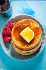 American pancakes with butter, maple syrup and raspberries 