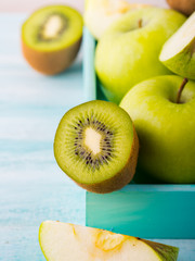 Green apples and kiwi on turquoise background