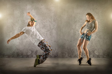 Fototapeta na wymiar Hip Hop dancer in dynamic action jump on the grunge grey backgro