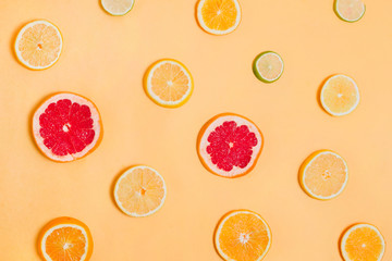 Pieces of various citrus fruits on orange background, concept of healthy eating, flatlay