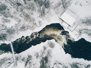 Aerial view of Icy river flowing through a beautiful snowy winter scenery in Oulanka National Park. Finland.