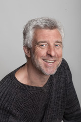  older gray-haired man sitting smiling