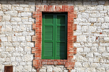 Old green window shutters of an mediterranean stone house