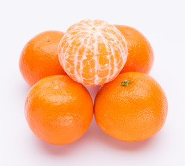 Pile of bright fresh tangerine fruits on a white background