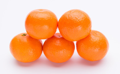 Pile of bright fresh tangerine fruits on a white background