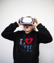 Teenager with virtual reality glasses on the head, enjoying watching, amazing technology, white background, studio