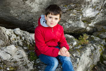 portrait of 9 year old boy with red jacket outside
