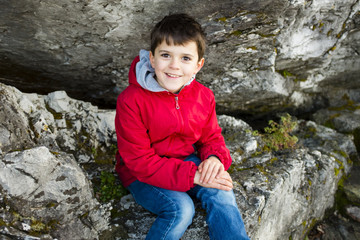 Naklejka na ściany i meble portrait of 9 year old boy with red jacket outside
