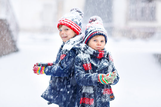 Happy children having fun with snow in winter
