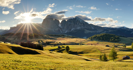Beautiful Scenery from Alpe di Siusi, Italy in summer sunrise light with small wooden cottage and sharp mountains of dolomite. Seiser Alm with Langkofel Group South Tyrol, Italy