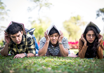 Fototapeta premium Teenager students outside protecting there heads by books exam stress hard concept