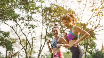 Fototapeta premium Two athletic woman running outdoors. Action and healthy lifestyle concept.Jogging run in park