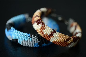 Two camouflage bracelets on a dark background close up