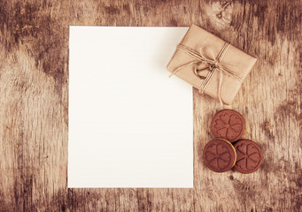 Gift boxes and cookies hearts on a wooden background. An empty sheet of paper and a gift. Romantic concept.