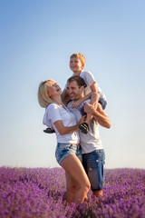 Happy family in a field of lavender on sunset.