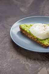 Sandwich with avocado and poached egg. Healthy breakfast