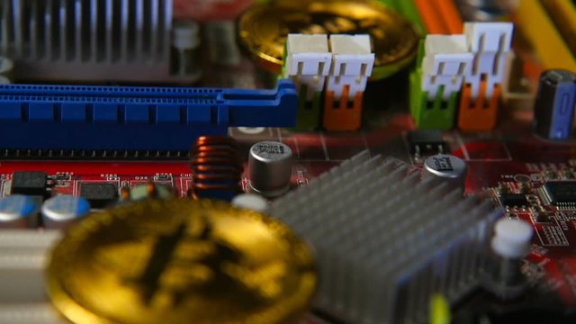Gold bitkoyn on the background of the motherboard. Video close up. The concept of virtual money.