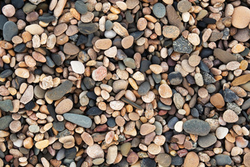 Small stones on shore textured background, overhead view, warm color