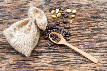 Roasted coffee beans seeds in sack on wood