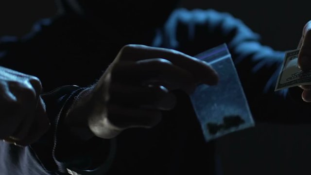 Police officer arresting drug dealer during transferring dose and taking money