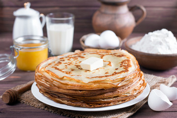 Traditional Ukrainian or Russian pancakes on a plate with butter. Russian bliny.