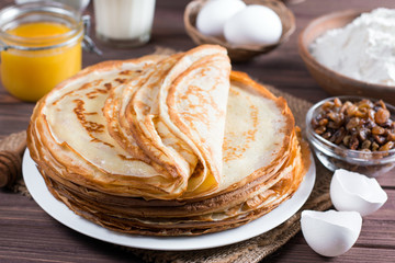 Many pancakes on a wooden background. Traditional Ukrainian or Russian pancakes. Shrovetide Maslenitsa.