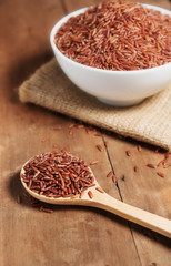Rice berry in wooden spoon wood background