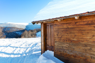 log cabin covered with snow