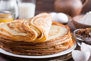 Many pancakes on a wooden background. Traditional Ukrainian or Russian pancakes. Shrovetide Maslenitsa.
